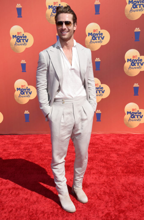 glen powell in a beige suit at the 2022 mtv movie & tv awards red carpet