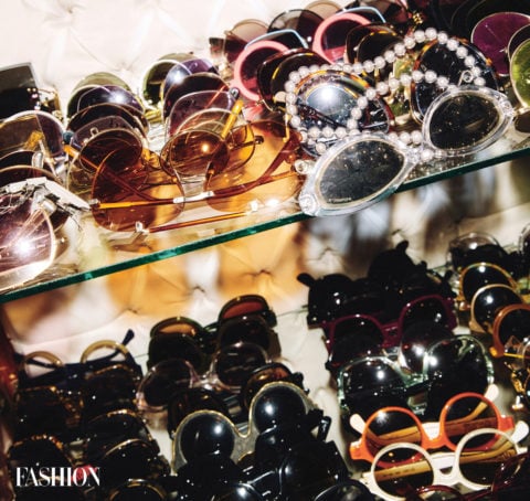 eyewear collection: two glass shelves overflowing with sunglasses of every shape, size and colour